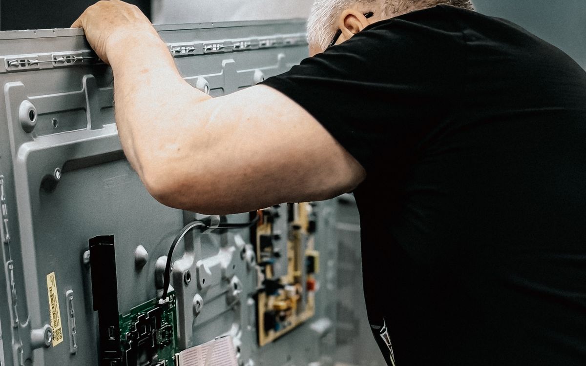 Technician repairing the board of an opened LED television